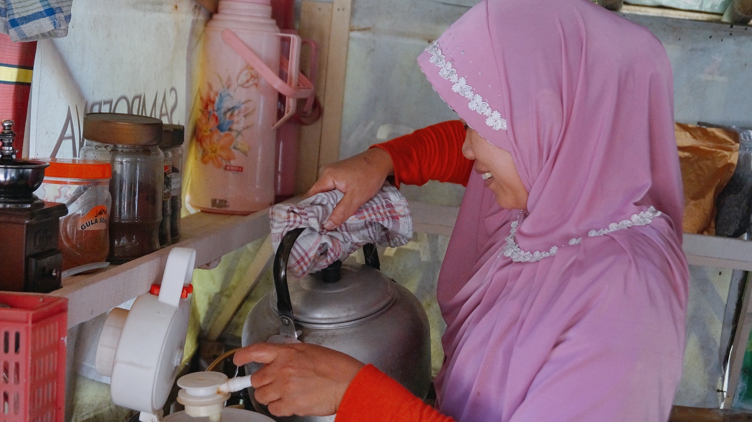 A woman pouring coffee made at the kedai kopi in Sokokembang.