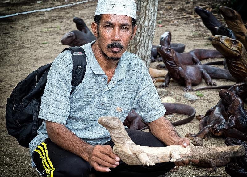 Local people in Komodo National Park depend on tourism for their livelihoods. This local man is selling wooden Komodo dragons.