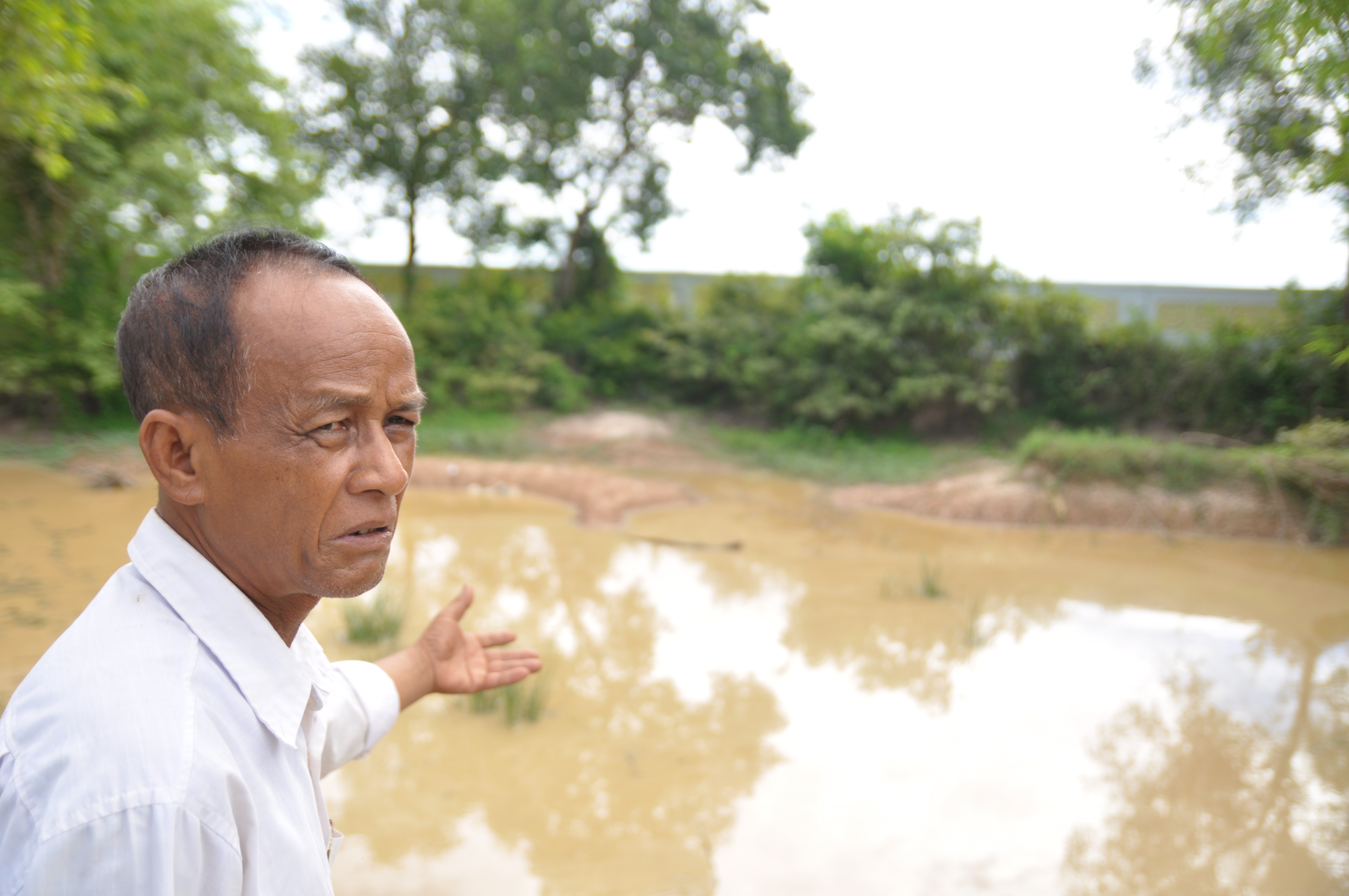 Tun Soun, a Khmer Krom survivor, points to one of the mass grave sites near Wat Pratheat (pagoda) in Kiri Vong district, Takeo province. The area was one of Cambodia’s most notorious prison and torture centres.
