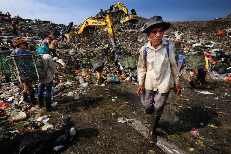 Trash picker at the Bantar Gebang open dumpsite. Poor landfill conditions.